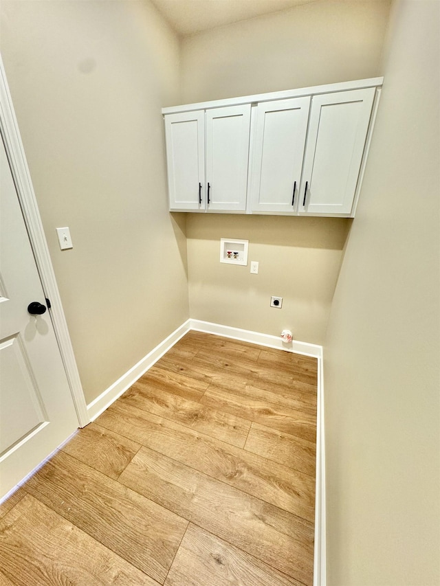 washroom with hookup for a washing machine, cabinet space, electric dryer hookup, light wood-type flooring, and baseboards