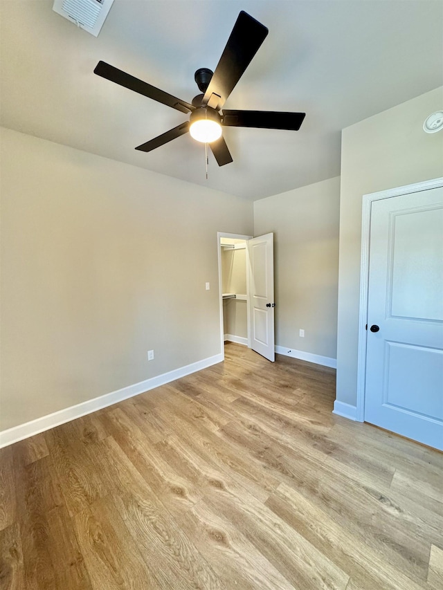 unfurnished bedroom featuring light wood-type flooring, visible vents, ceiling fan, and baseboards