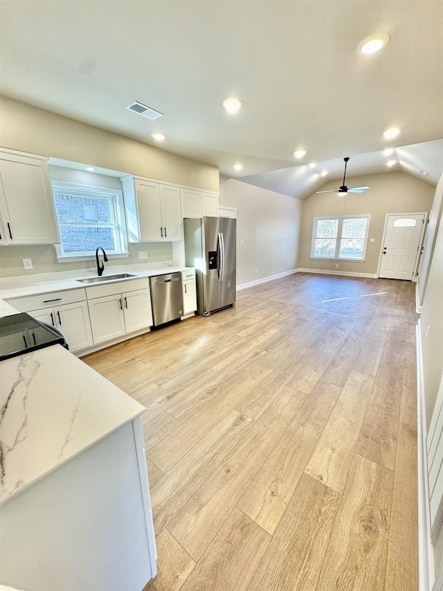 kitchen with visible vents, appliances with stainless steel finishes, light wood-style floors, a healthy amount of sunlight, and a sink