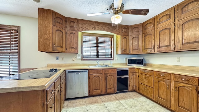 kitchen featuring a textured ceiling, ceiling fan, sink, and stainless steel appliances