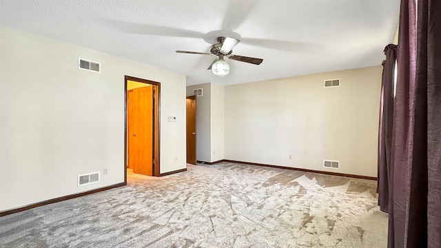 carpeted spare room featuring ceiling fan