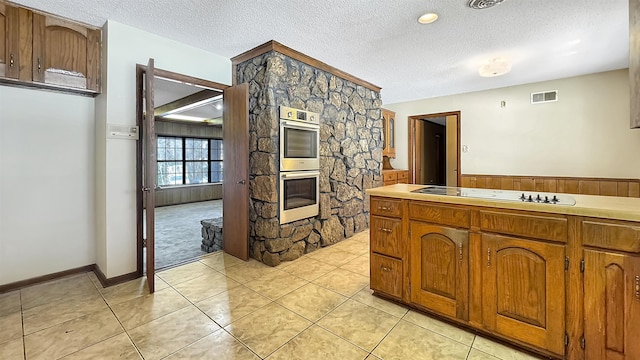 kitchen featuring white electric cooktop, light tile patterned floors, a textured ceiling, and double oven