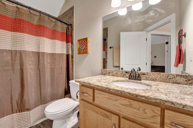 bathroom with vanity, toilet, lofted ceiling, and walk in shower