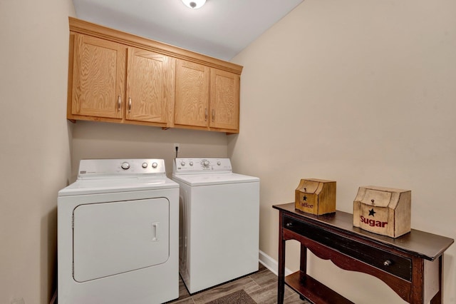 washroom with washing machine and clothes dryer and cabinets