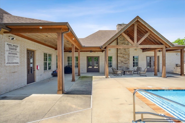 view of pool with ceiling fan, a patio area, and french doors