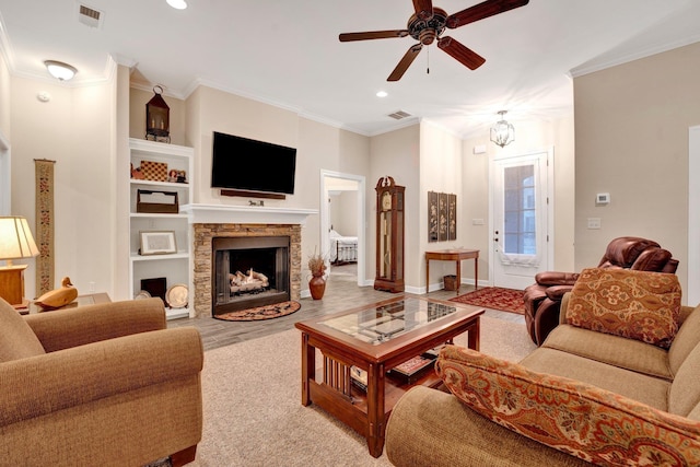 living room featuring ceiling fan with notable chandelier, light hardwood / wood-style floors, crown molding, and a fireplace