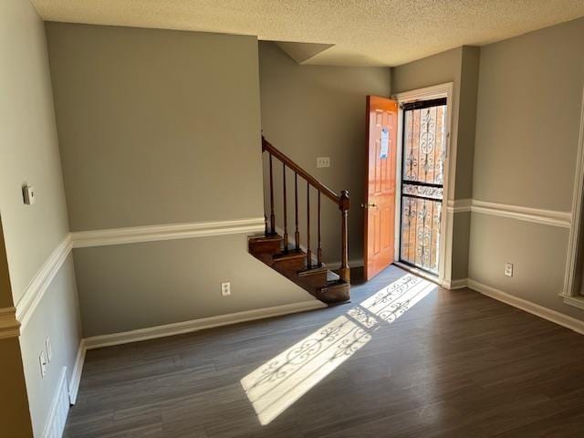 entryway featuring a textured ceiling and dark wood-type flooring