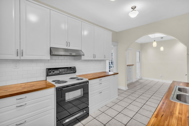 kitchen with butcher block countertops, electric range, white cabinetry, and light tile patterned flooring