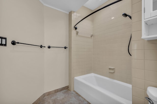 bathroom with toilet, ornamental molding, and tiled shower / bath