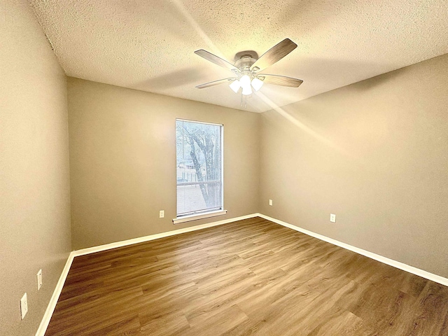 empty room with a textured ceiling, ceiling fan, and hardwood / wood-style flooring