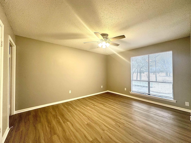 spare room featuring a textured ceiling, ceiling fan, and wood-type flooring