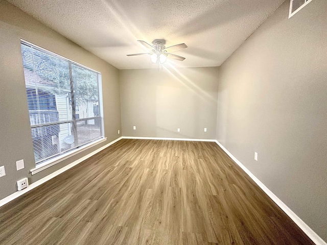 spare room with hardwood / wood-style flooring, a textured ceiling, and ceiling fan