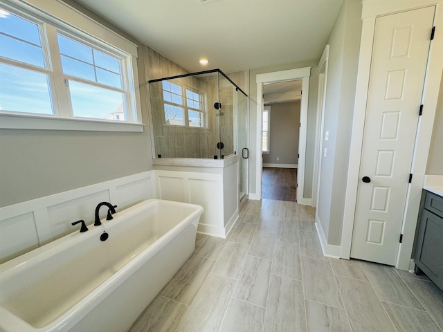 bathroom featuring separate shower and tub, a wealth of natural light, and vanity