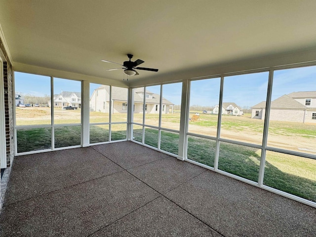 unfurnished sunroom with ceiling fan and a healthy amount of sunlight