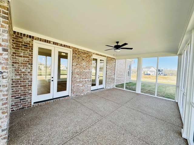 unfurnished sunroom featuring ceiling fan, french doors, and a wealth of natural light