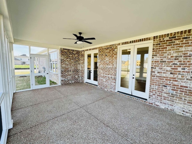 unfurnished sunroom featuring ceiling fan and french doors