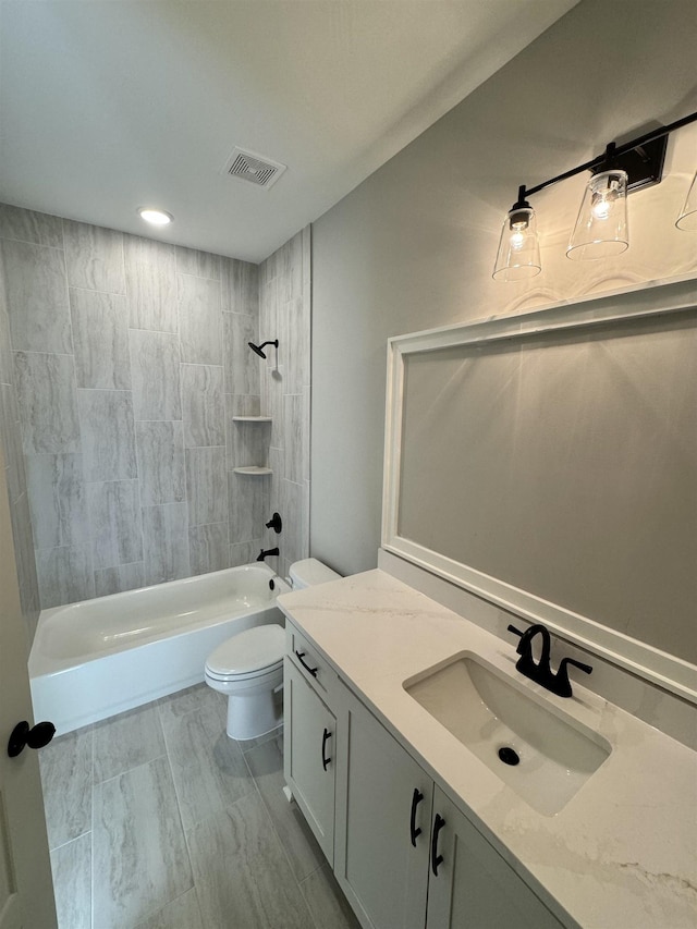 full bathroom with toilet, vanity, and tiled shower / bath