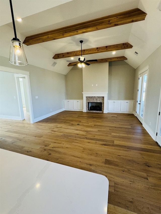 unfurnished living room with ceiling fan, lofted ceiling with beams, and dark hardwood / wood-style floors