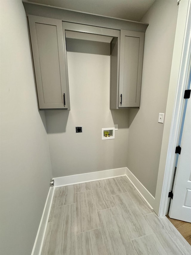 clothes washing area with washer hookup, cabinets, and hookup for an electric dryer