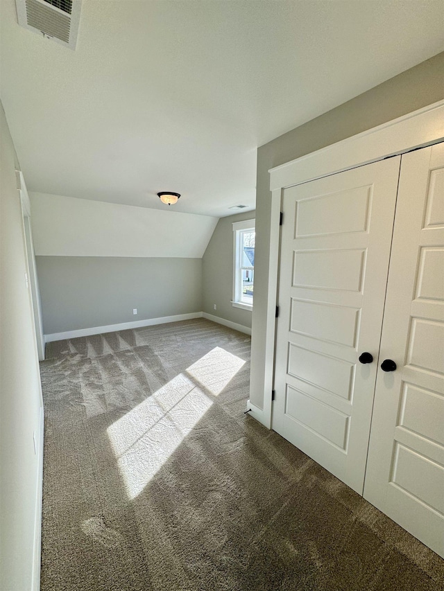 additional living space with carpet floors and vaulted ceiling