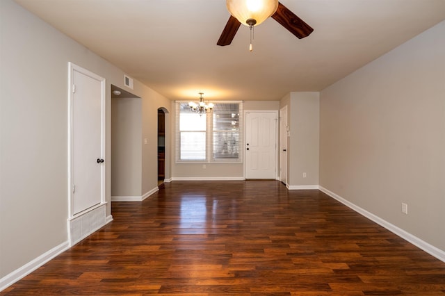 spare room with ceiling fan with notable chandelier and dark hardwood / wood-style flooring