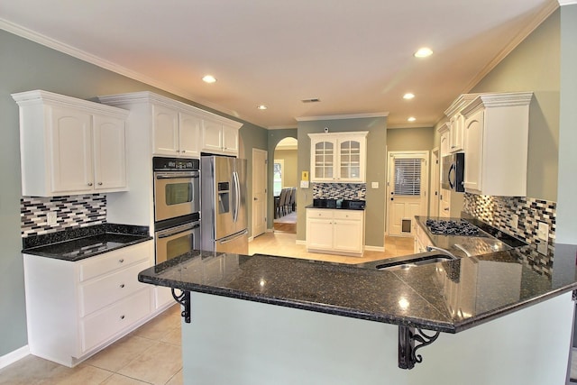 kitchen featuring appliances with stainless steel finishes, white cabinetry, sink, and kitchen peninsula