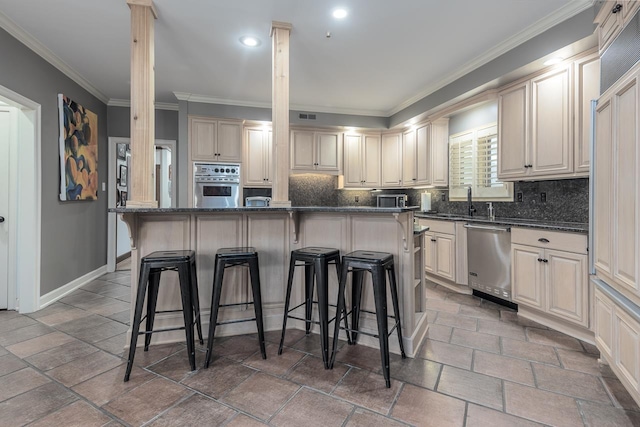 kitchen with stainless steel appliances, a breakfast bar area, dark stone countertops, and a kitchen island