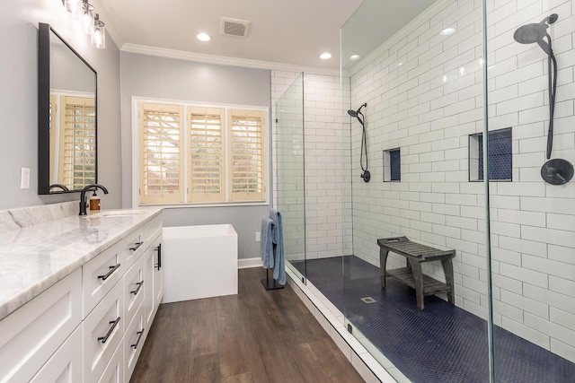 bathroom with an enclosed shower, vanity, hardwood / wood-style floors, and crown molding