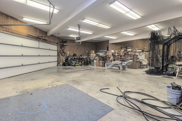 garage featuring wood walls and a garage door opener