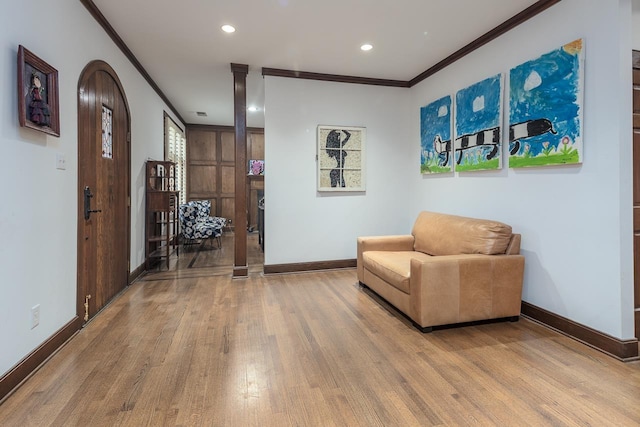 sitting room featuring ornamental molding, wood-type flooring, and ornate columns