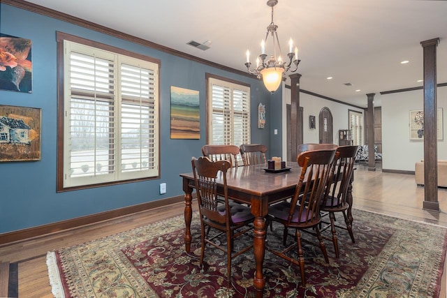 dining area featuring ornate columns, a wealth of natural light, and crown molding