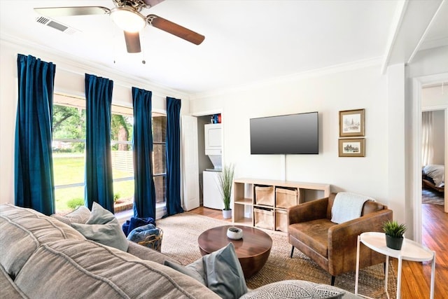 living room with hardwood / wood-style floors, ceiling fan, and crown molding