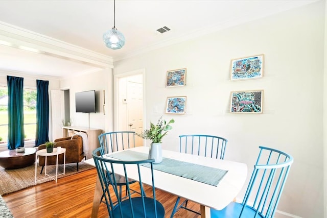 dining room featuring wood-type flooring and crown molding