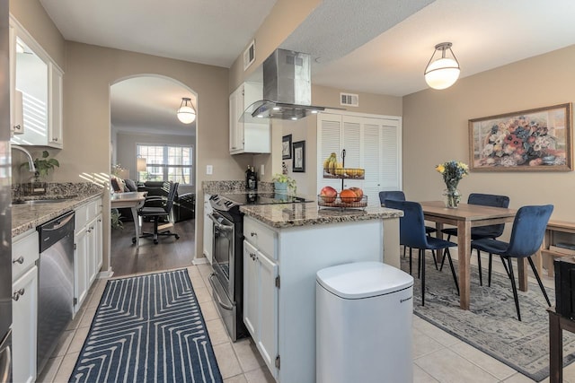 kitchen with stainless steel appliances, sink, white cabinetry, light stone countertops, and extractor fan