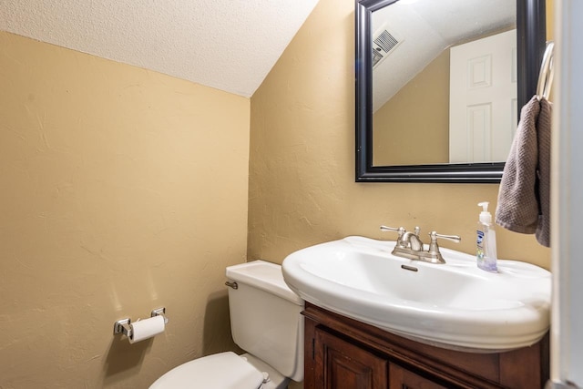 bathroom with sink, toilet, a textured ceiling, and vaulted ceiling