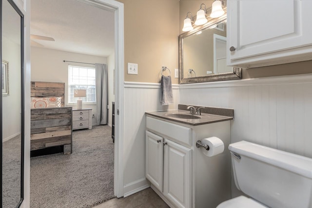 bathroom featuring ceiling fan, vanity, and toilet