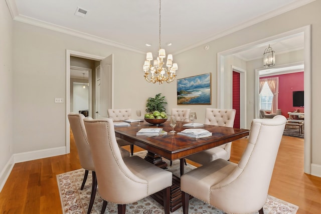 dining space with ornamental molding, a notable chandelier, and wood-type flooring