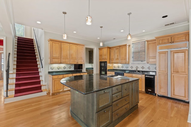 kitchen featuring black appliances, a center island, decorative light fixtures, and tasteful backsplash