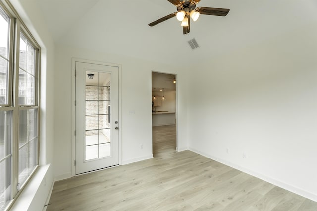 spare room with vaulted ceiling, ceiling fan, a wealth of natural light, and light hardwood / wood-style flooring