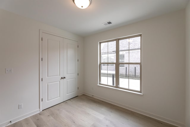 unfurnished bedroom featuring a closet and light wood-type flooring