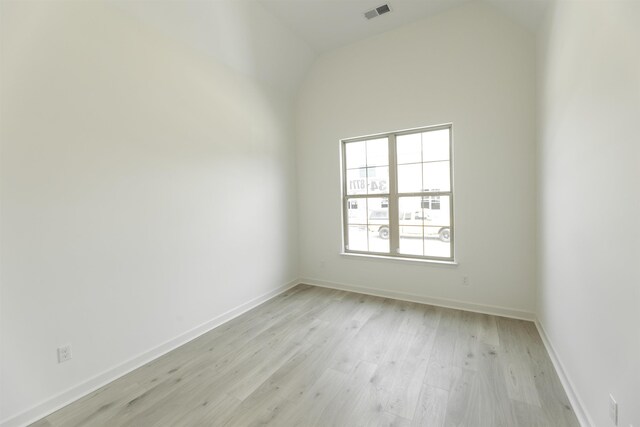 spare room featuring high vaulted ceiling and light hardwood / wood-style floors