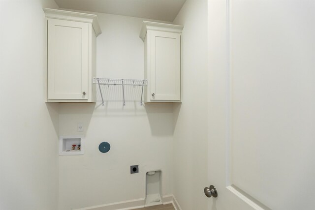 laundry area with electric dryer hookup, hookup for a washing machine, and cabinets