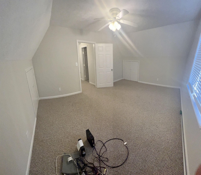 additional living space with ceiling fan, vaulted ceiling, and carpet