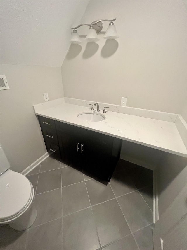 bathroom with vanity, tile patterned flooring, toilet, and vaulted ceiling