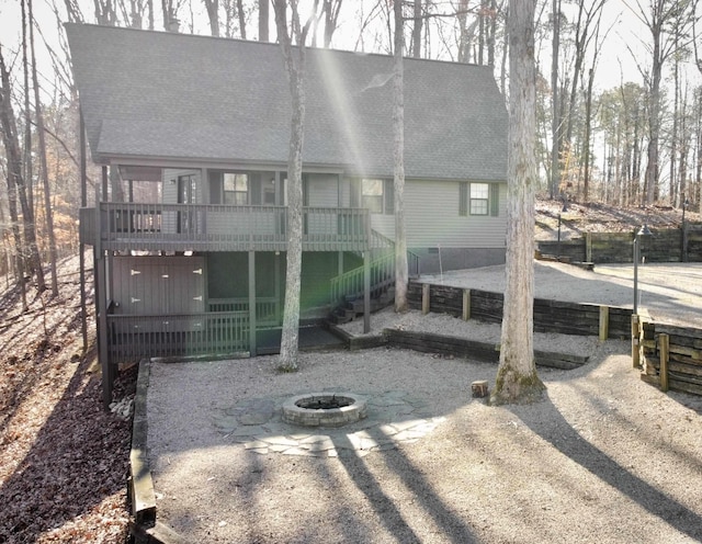 back of house with a fire pit and a wooden deck