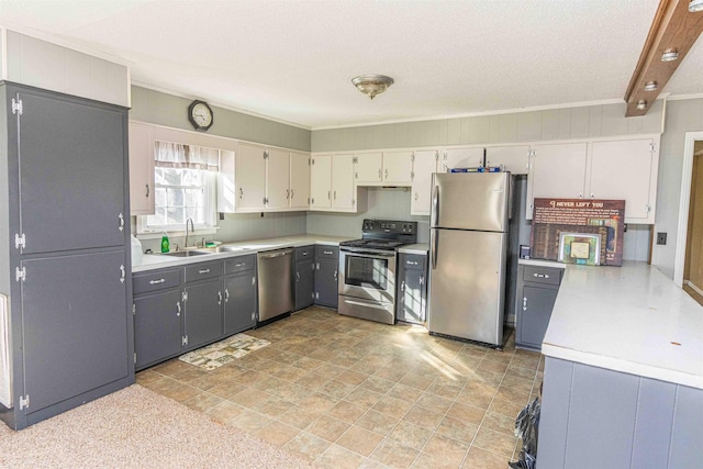 kitchen with a textured ceiling, stainless steel appliances, gray cabinets, crown molding, and sink