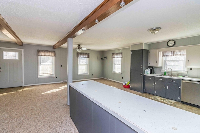 kitchen with stainless steel dishwasher, beam ceiling, gray cabinets, ceiling fan, and sink