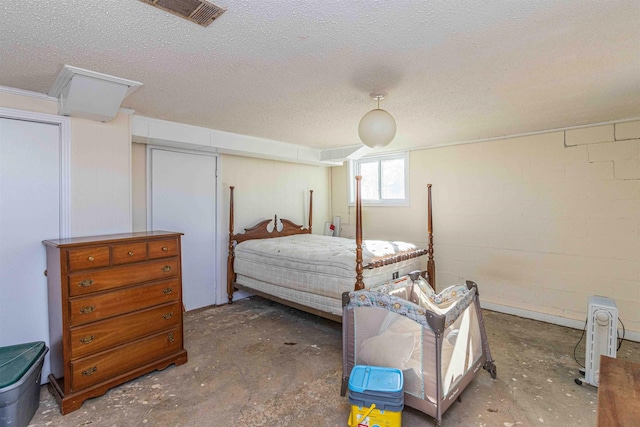 bedroom featuring a textured ceiling and concrete flooring