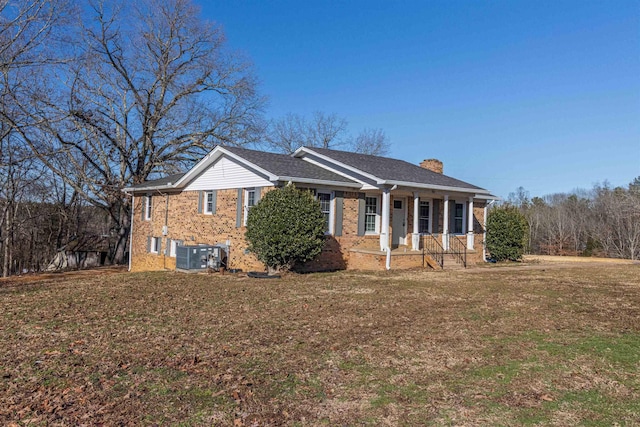 view of front of house featuring covered porch, central AC unit, and a front yard