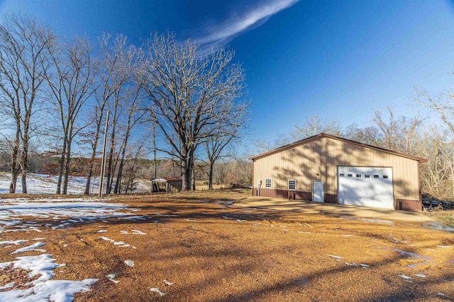 exterior space with a garage and an outbuilding